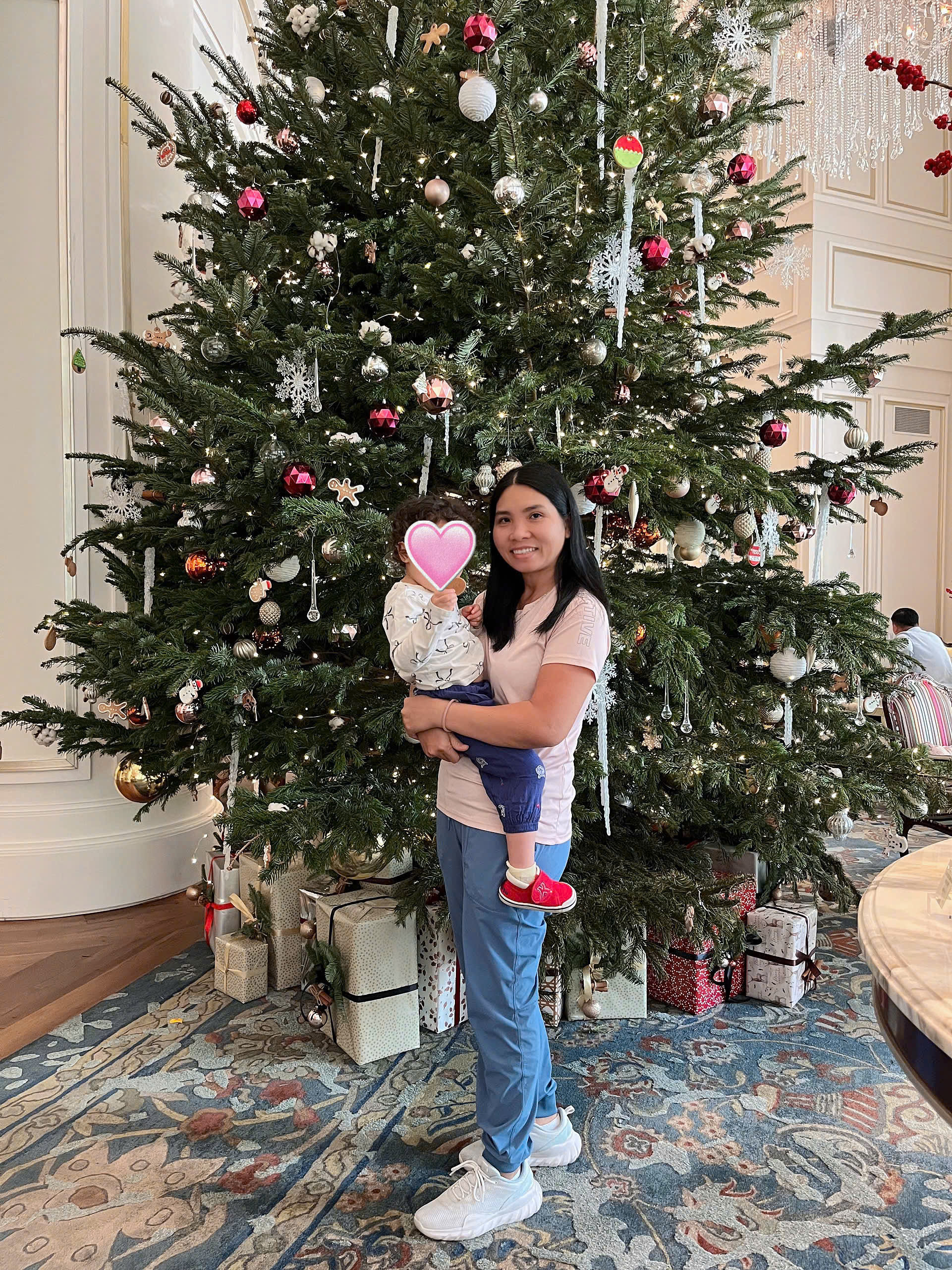 Happy family and children with English-speaking babysitter Anh Nguyen in Vietnam - Festive holiday cheer admiring Christmas decorations