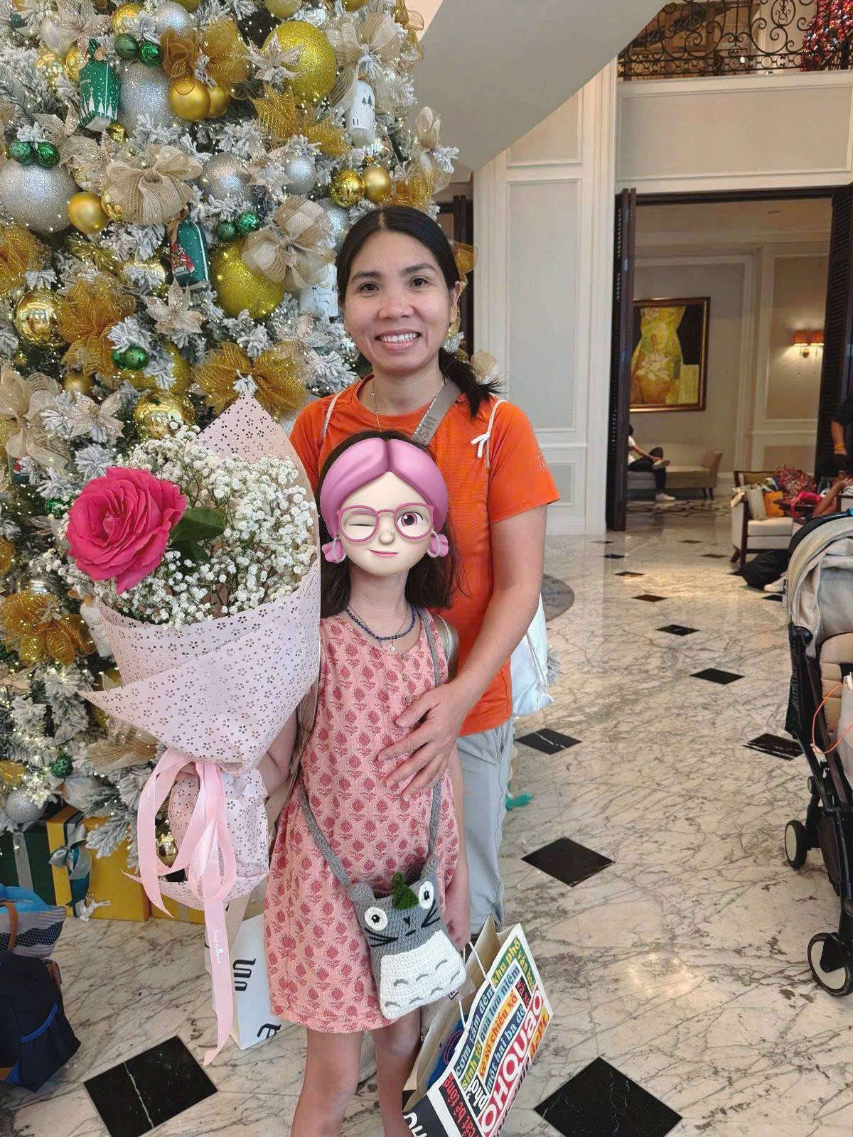 Happy family and children with English-speaking babysitter Anh Nguyen in Vietnam - Special holiday memories with flower bouquet by Christmas tree