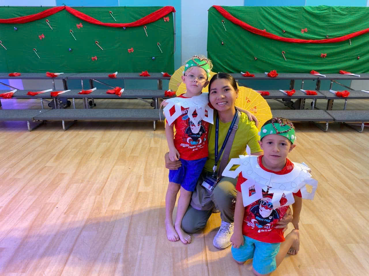 Happy family and children with English-speaking babysitter Anh Nguyen in Vietnam - Supporting milestones at a festive holiday school play